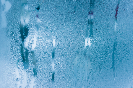 Background of natural water condensation, window glass with high air humidity, large drops drip. Collecting and streaming downの写真素材