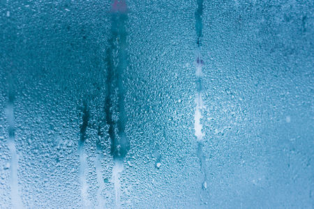 Background of natural water condensation, window glass with high air humidity, large drops drip. Collecting and streaming downの写真素材
