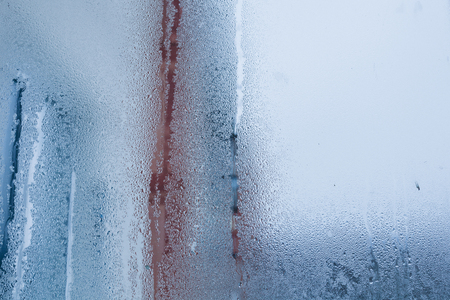Blurry abstract background of foggy condensation on window glass natural surface. High humidity with formation of water dropletsの写真素材