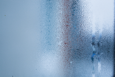 Blurry abstract background of foggy condensation on window glass natural surface. High humidity with formation of water dropletsの写真素材