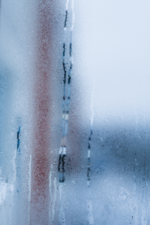 Blurry abstract background of foggy condensation on window glass natural surface. High humidity with formation of water dropletsの写真素材