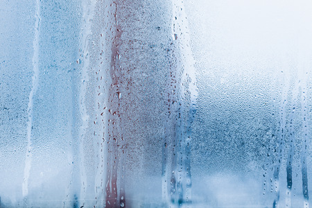 Background of natural water condensation, window glass with high air humidity, large drops drip. Collecting and streaming downの写真素材