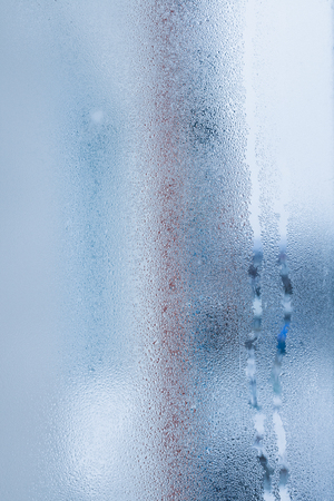 Blurry abstract background of foggy condensation on window glass natural surface. High humidity with formation of water dropletsの写真素材