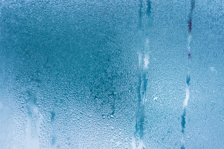 Background of natural water condensation, window glass with high air humidity, large drops drip. Collecting and streaming downの写真素材