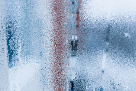 Background of natural water condensation, window glass with high air humidity, large drops drip. Collecting and streaming downの写真素材