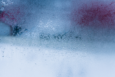 Hot water vapor condensed on the cold window glass, macro texture or backgroundの写真素材