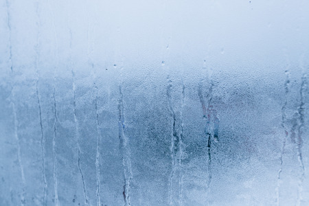 Blurry abstract background of foggy condensation on window glass natural surface. High humidity with formation of water dropletsの写真素材