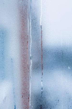 Blurry abstract background of foggy condensation on window glass natural surface. High humidity with formation of water dropletsの写真素材