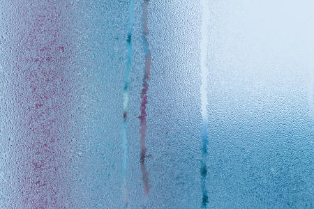 Hot water vapor condensed on the cold window glass, macro texture or backgroundの写真素材