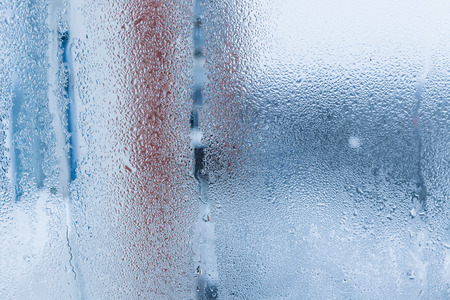 Background of natural water condensation, window glass with high air humidity, large drops drip. Collecting and streaming downの写真素材