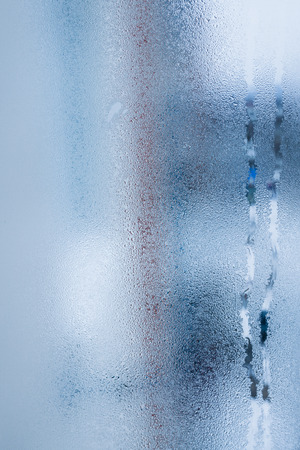 Blurry abstract background of foggy condensation on window glass natural surface. High humidity with formation of water dropletsの写真素材