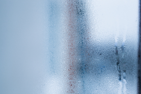 Blurry abstract background of foggy condensation on window glass natural surface. High humidity with formation of water dropletsの写真素材