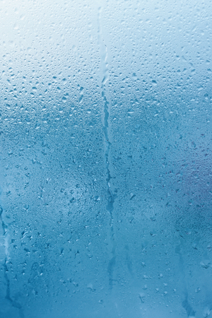 Window glass with high humidity condensation. Natural water background. Vertical photo. Copy spaceの写真素材