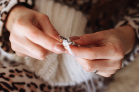 The woman hands knitting woolen clothes. Knitting needles. Close-up. Natural wool. Horizontal photo. Freelance creative working and living conceptの写真素材