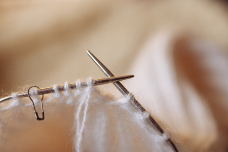 Wool thread and knitting needle are shown in close-up with a blurred background. Copy space. Cozy home warm conceptの写真素材