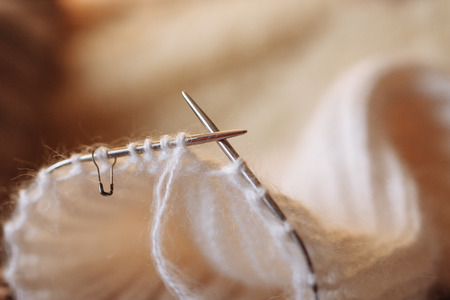 Wool thread and knitting needle are shown in close-up with a blurred background. Copy space. Cozy home warm conceptの写真素材