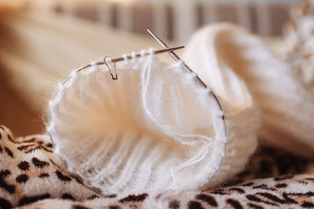 Wool thread and knitting needle are shown in close-up with a blurred background. Copy space. Cozy home warm conceptの写真素材