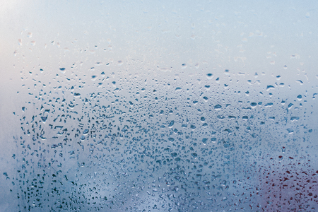 Misted glass background. Strong humidity in wintertime. Water drops from home condensation on a windowの写真素材