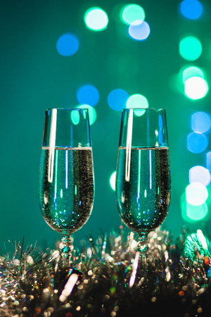 Glasses with champagne against fireworks and holiday lights - Celebrating the New Yearの写真素材