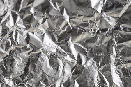 Silver crumpled foil shiny metal texture background wrapping paper for wallpaper decoration element....