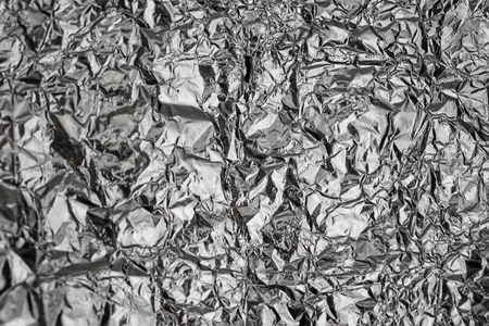 Silver crumpled foil shiny metal texture background wrapping paper for wallpaper decoration element. Grey platinum metallicの写真素材