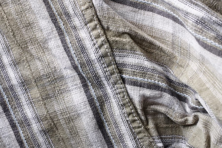 Close up part of a shirt from hemp fabric. Casual man's shirt with pattern. Wrinkled texture from...