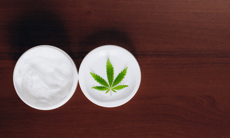 Detail of cannabis hemp cream with marijuana leaf - cannabis topicals concept. Cream from biological and ecological plants of hemp vegetable pharmaceutical oil CBDの写真素材