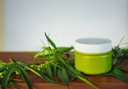 Cannabis hemp cream background with marijuana leaf - cannabis concept self care in of health care. Cosmetics with hemp extract on table. Herbal organic medicine CBD productの写真素材