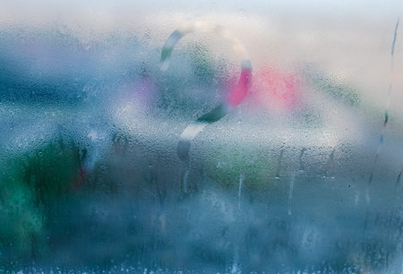 Moist word written on wet window. High level of dampness in apartment. Window glass with high air...