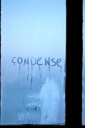 Inscription condense on glass with drops of condensed vapor with drops of water. Close up detail of moisture condensation problems. Hot water vapor condenses on the cold glass in the bathroomの写真素材