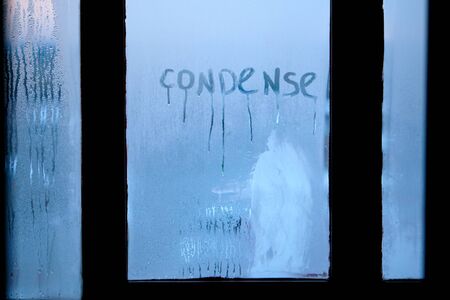Inscription condense on glass with drops of condensed vapor with drops of water. Close up detail of moisture condensation problems. Hot water vapor condenses on the cold glass in the bathroomの写真素材