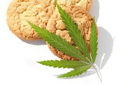 Cookies with cannabis leaf and marijuana macro. Cannabis CBD cannabidiol Concept of cooking with hemp herb. Treatment of medical marijuana for use in food, use CBDの写真素材