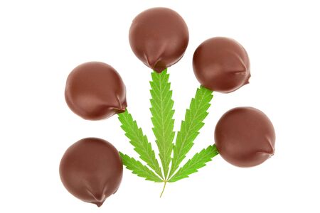 Sweet cannabis candy containing CBD cannabidiol, green marijuana leaves on white isolated background. Candy with the addition of medical cannabis CBD for recreational use to relax the body and mindの写真素材