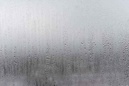 Close up for misted glass with droplets of water draining down. Dripping Condensation, Water Drops Background Rain drop Condensation Textureの写真素材