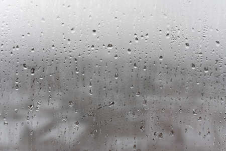 Close up water drop on gray background, misted glass with droplets of water draining down. Dripping Condensationの写真素材