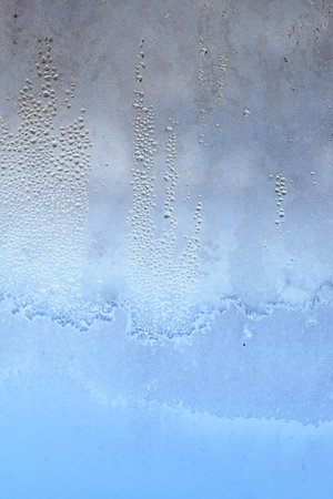The texture of frozen drops of condensation on a transparent glass window. Water drops. Rain. Abstract texture background. A sharp cold snap, a frozen drop of water on the glass in winterの写真素材