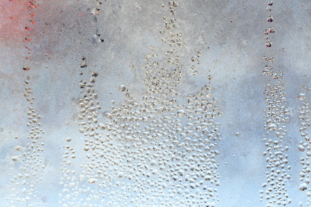 The texture of frozen drops of condensation on a transparent glass window. Water drops. Rain. Abstract texture background. A sharp cold snap, a frozen drop of water on the glass in winterの写真素材