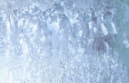 Frozen drops of condensation on a window, a sharp drop in temperature, sharply frozen drops of water on glass in winter, extremely cold low air temperaturesの写真素材
