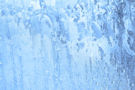 Natural frozen drops of condensation on transparent glass. Beautiful background from a frozen window in winter. Drops texture on the glassの写真素材