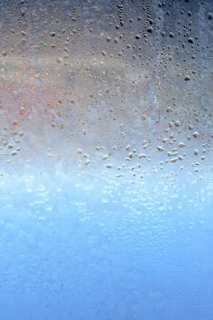 Frozen drops of condensation on a window, a sharp drop in temperature, sharply frozen drops of water on glass in winter, extremely cold low air temperaturesの写真素材