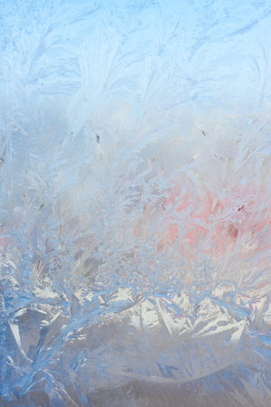 Vertical image of a winter background on a transparent glass window with a frozen texture. Abstract texture background, vertical photo, copy space for your design or textの写真素材