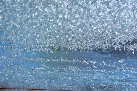 Winter background on a transparent glass of a window with a frozen texture. Abstract texture background, horizontal image, copy space for your design or textの写真素材