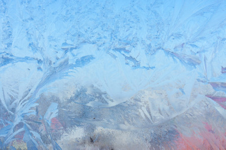Completely frozen window on transparent glass. Clean background. Extreme low temperatures in winter. Water vapor condenses on cold window glass and freezesの写真素材