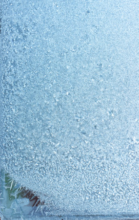 Beautiful natural background or texture of frozen transparent glass on the window in winter, extreme cold concept, vertical image, copy space for your design or textの写真素材