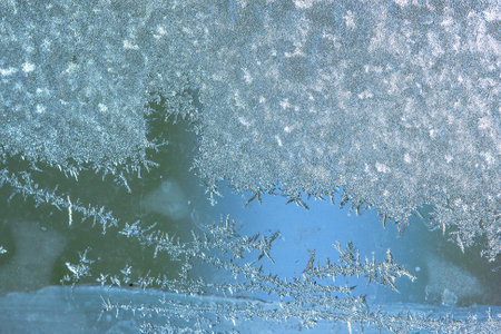 Beautiful natural background or texture of frozen transparent glass on the window in winter, strong cold concept, horizontal image, copy space for your design or textの写真素材