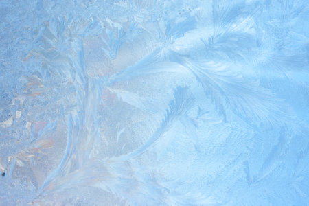 Winter background on a transparent glass of a window with a frozen texture. Abstract texture background, horizontal image, copy space for your design or textの写真素材