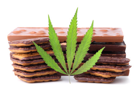 Chocolate with marijuana extract, chocolate biscuits with CBD content. Entertainment drugs concept. Chocolate bars with nuts and CBD cannabis content, green hemp leaf on white isolated background.の写真素材