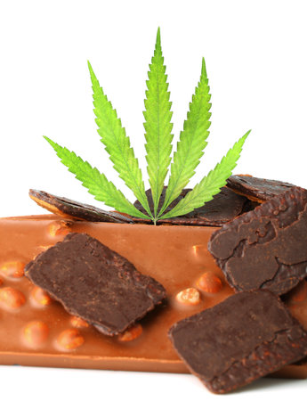 Edible medical marijuana food chocolate bars and chocolate cookies with green hemp leaf isolated on white background. Cannabis chocolates CBDの写真素材