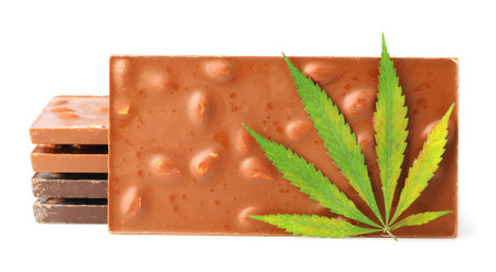 Chocolate bars and biscuits close-up with hemp leaf on white isolated background. Chocolate marijuana dessert cookies with CBD cannabisの写真素材