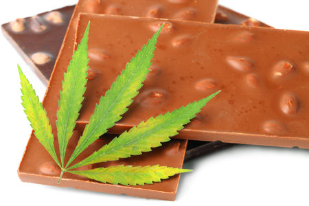 Healthy tasty chocolate chip marijuana cookie with green hemp leaf, CBD chocolate isolated white backgroundの写真素材